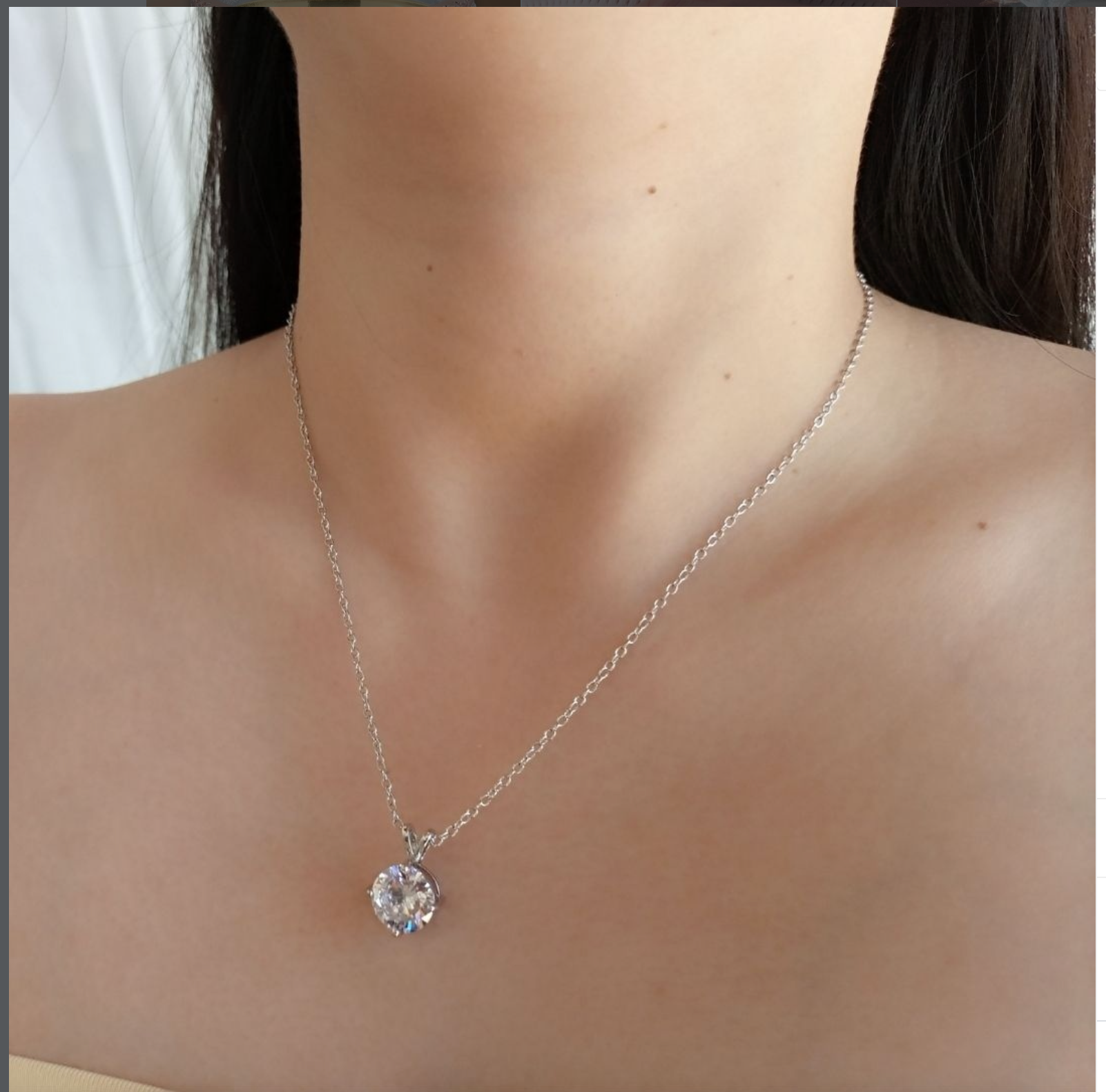 A close-up model shot of the gold Upsera Solitaire Necklace resting elegantly on the collarbone, showcasing its substantial weight and radiant AAA Zirconia center stone.